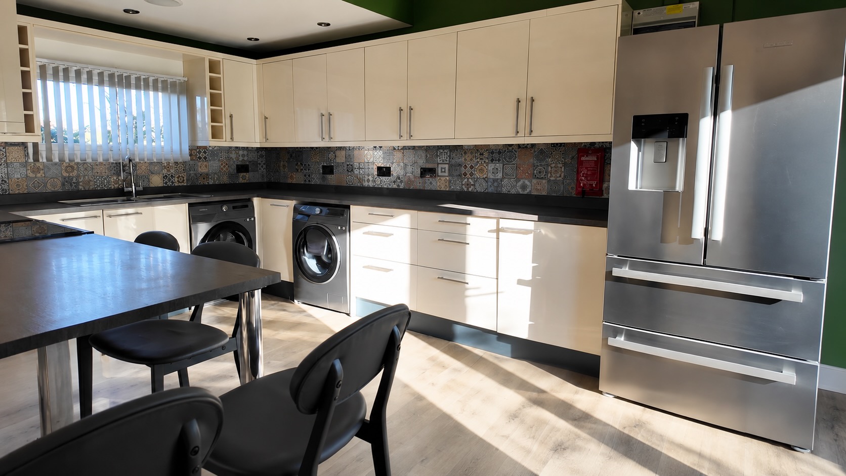 Fully equipped retreat kitchen with cream cabinets and stainless steel appliances