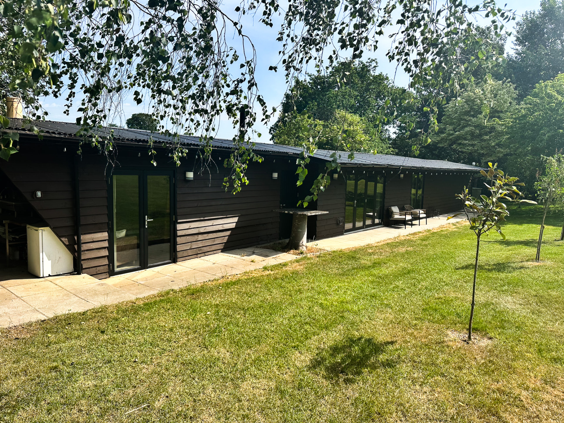 Exterior of the Elysium Grove retreat lodge with patio and private lawns
